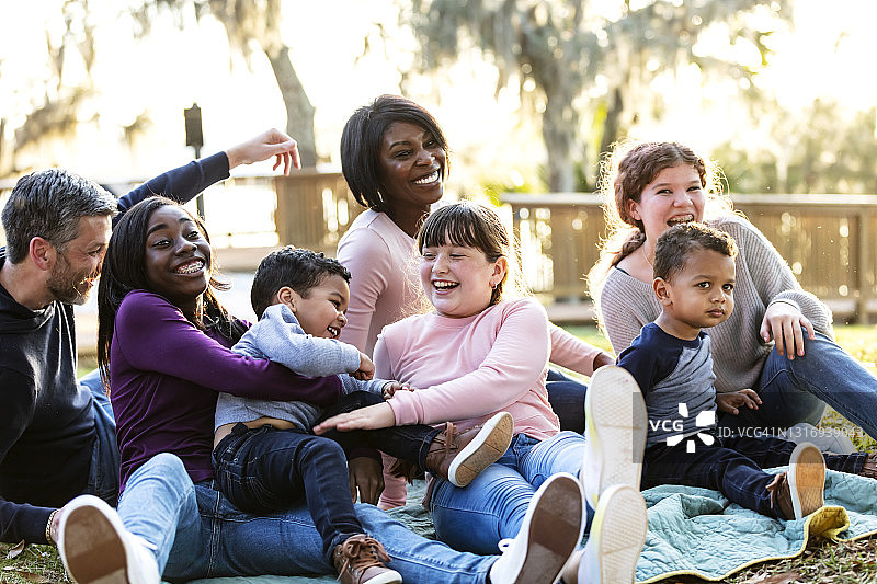 在公园里欢笑的五孩混合家庭图片素材