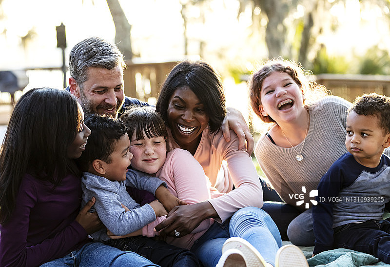 在公园里欢笑的五孩混合家庭图片素材