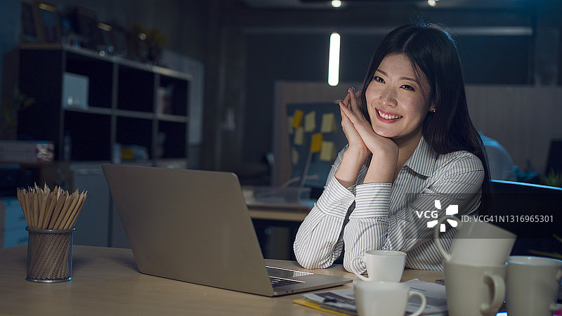 在办公室工作的快乐女商人图片素材