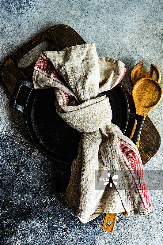 砧板上的平底锅和木制沙拉用具及茶巾图片素材