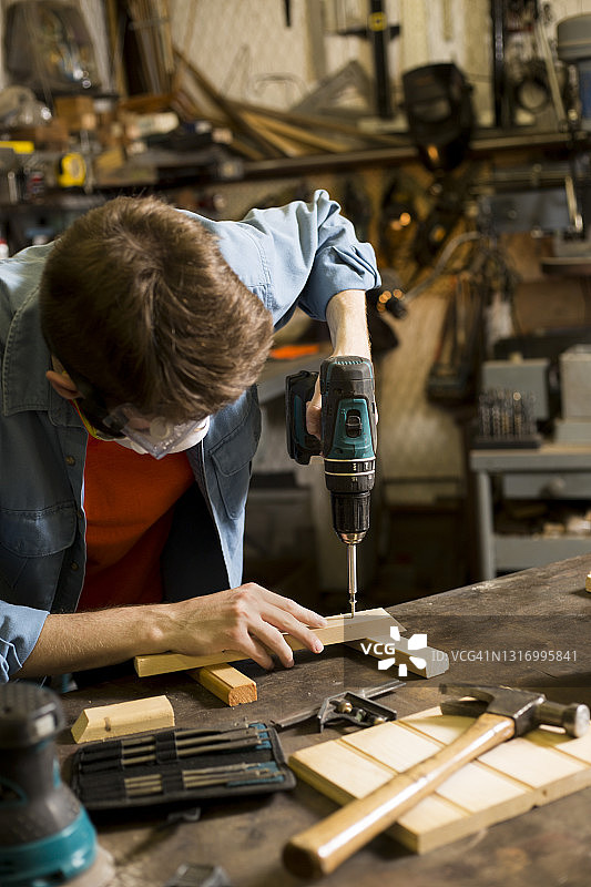 年轻白人男子在小型工作室工作图片素材