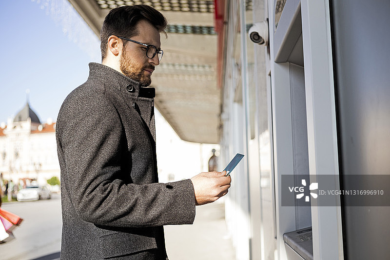 年轻男人使用ATM机图片素材