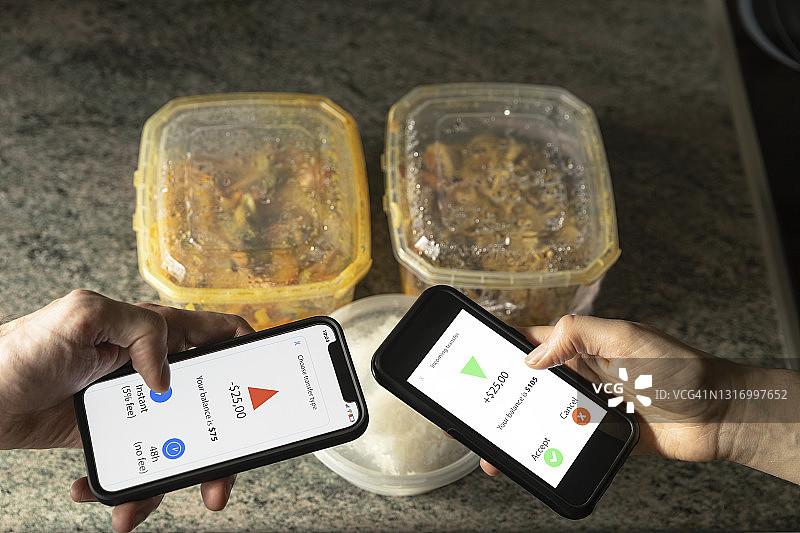 两个人在用智能手机应用程序交换货币图片素材