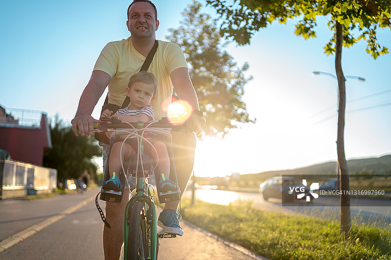 父亲用儿童座椅带着儿子骑自行车图片素材