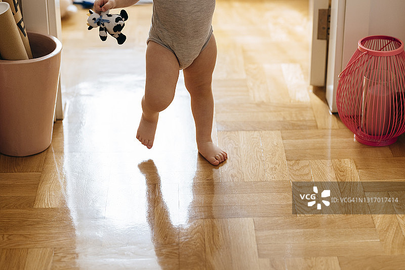 在家抱着毛绒玩具走路的女婴图片素材