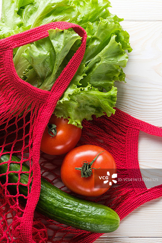 可重复使用购物袋中的新鲜多汁蔬菜和绿色沙拉，木质或厨房桌背景。素食主义，纯素食主义，生食。无塑料环保生活方式。图片素材