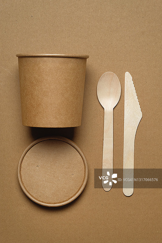 可降解的一次性餐具，由可回收的塑料和纸在米色背景。保护、关怀、环保的理念。环保可持续的生活方式。图片素材