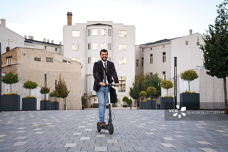 骑电动滑板车的英俊商人图片素材