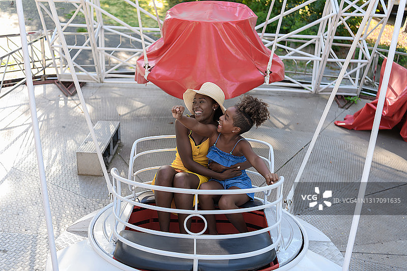 一个非裔美国家庭在游乐园里乘坐摩天轮图片素材