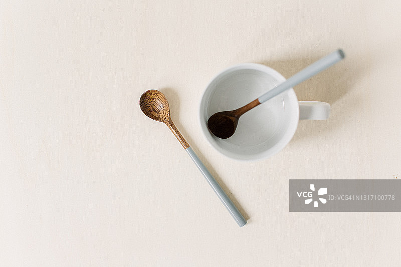现代餐具静物，在日光工作室中从上方拍摄，两人份：一个杯子和两个小木勺，留有复制空间图片素材