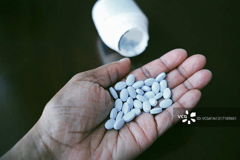 手心拿着药丸的女人图片素材
