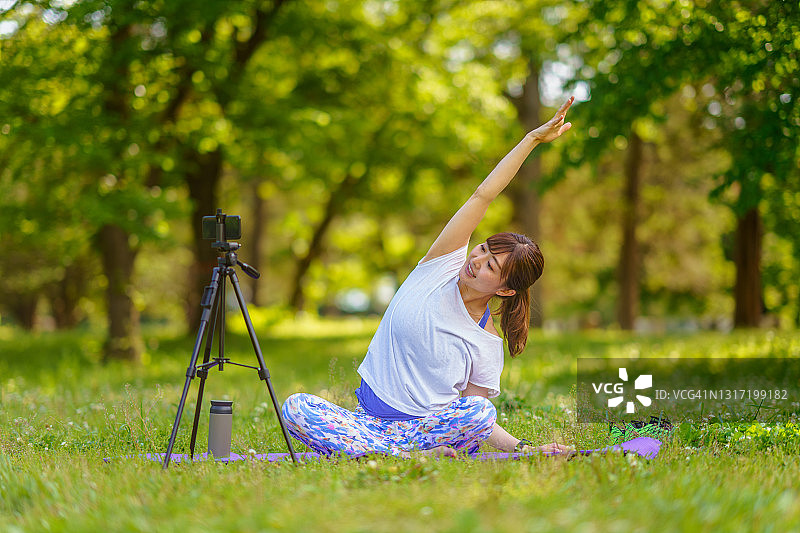 瑜伽教练在户外进行在线教学图片素材