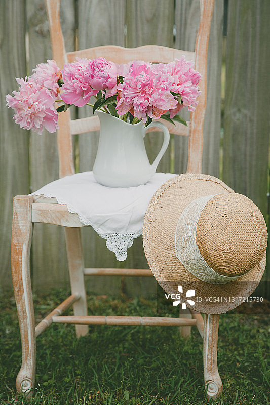 梯子靠背椅，粉色牡丹与草帽，木栅栏外的田园风光图片素材