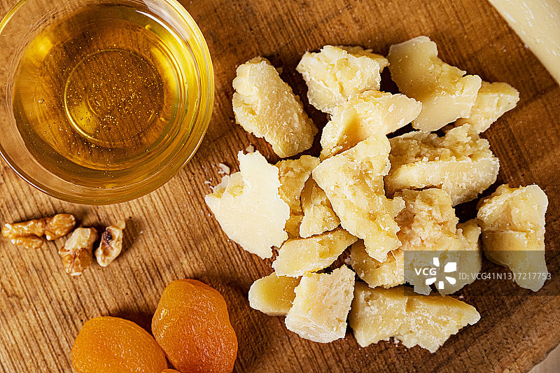 意式经典奶酪：罗马羊乳干酪、核桃、蜂蜜和桃干，木制砧板高清细节图，适用于杂志、网站和社交媒体，厨房、餐厅和食品生产相关素材图片素材