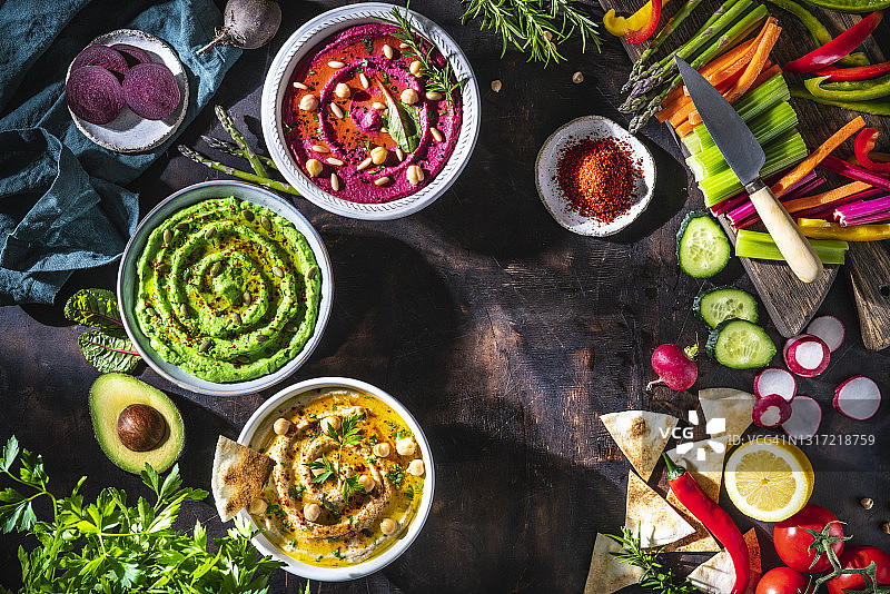 三碗鹰嘴豆泥：鹰嘴豆、鳄梨和甜菜根配蔬菜条图片素材