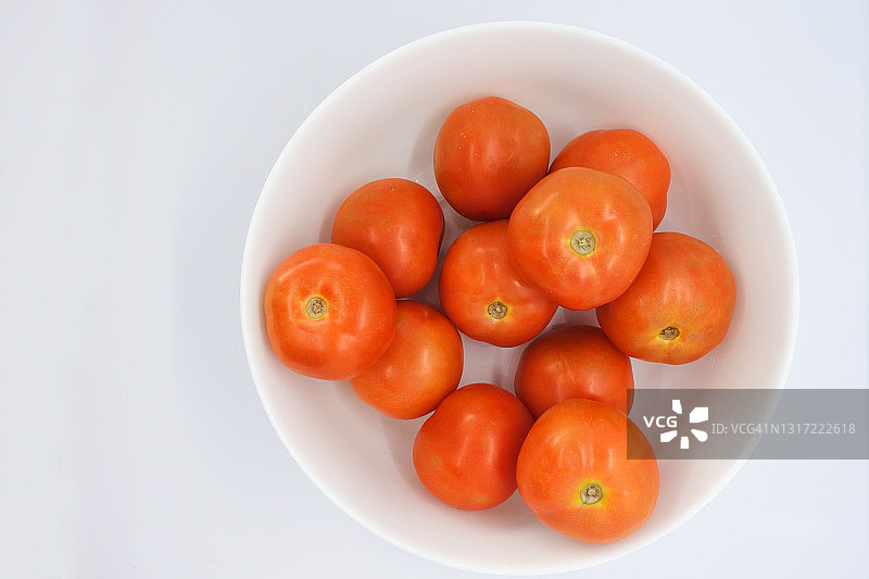 白色背景白碗中的新鲜红番茄图片素材