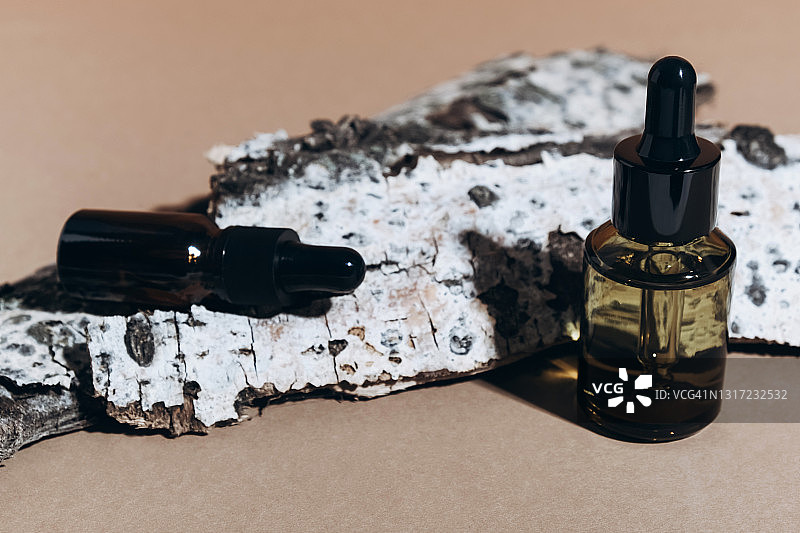 阳光下木头上的棕色化妆品罐子与滴管图片素材