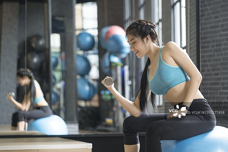 年轻女人健身房锻炼特写图片素材