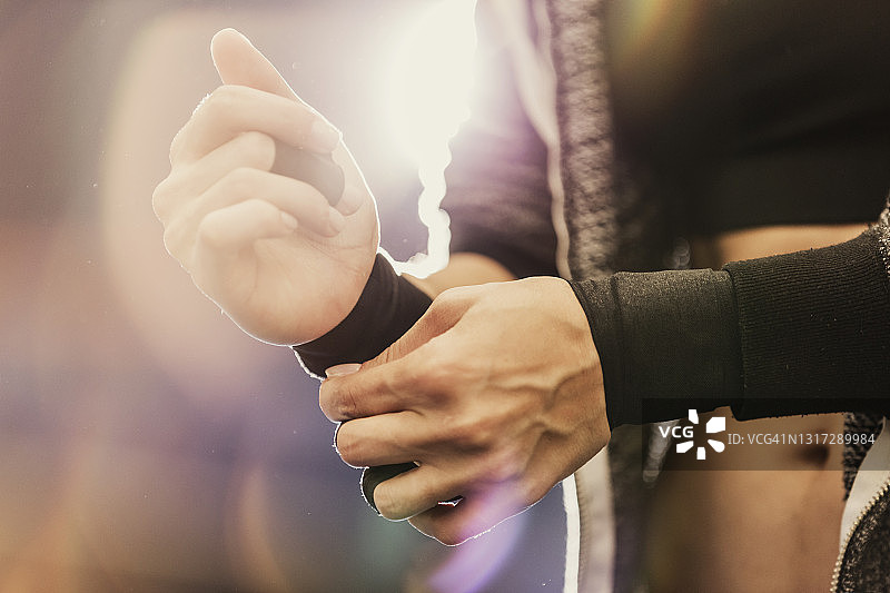 女子在健身房调整护腕图片素材