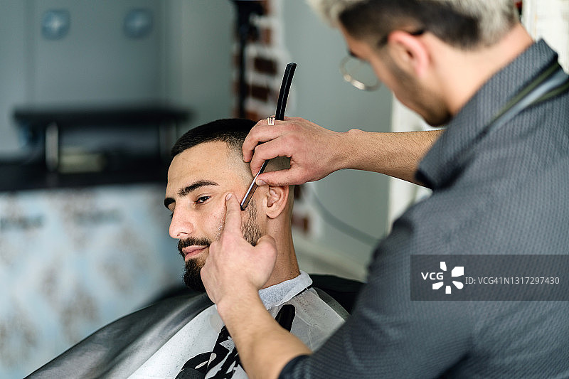 男人用剃须刀修剪胡须图片素材