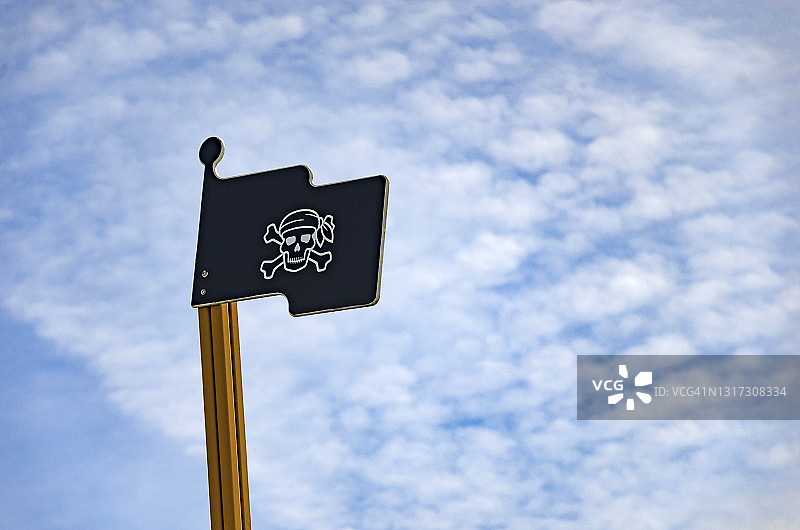 天空背景下的木制海盗旗仰视角度图片素材