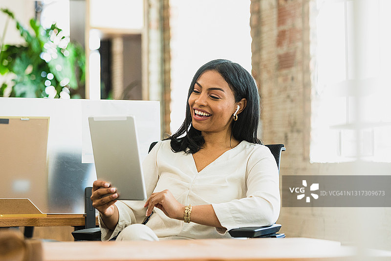 戴着耳机用平板电脑进行电话会议的商务女人图片素材
