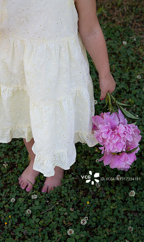 草地上提着花的小孩图片素材