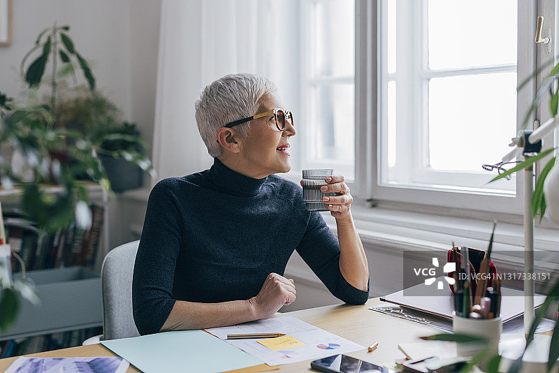 在家办公饮水的年长女商人图片素材
