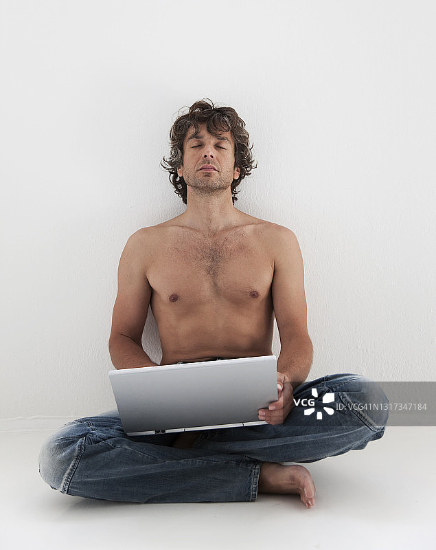 男人坐在地板上使用笔记本电脑图片素材
