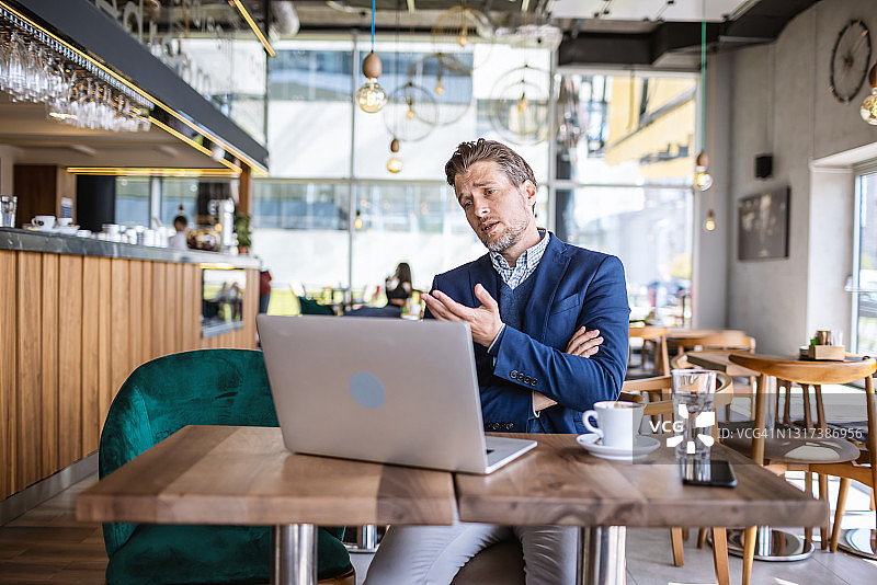 商人在咖啡馆使用笔记本电脑图片素材