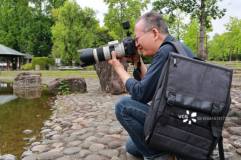 携带相机包的日本摄影师图片素材