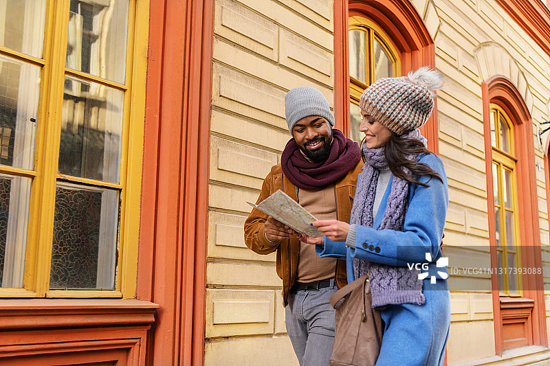 年轻的多元种族旅行者使用旅游地图在城市观光图片素材