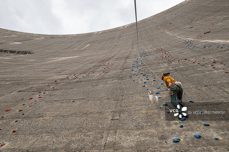 在瑞士攀爬混凝土水坝的男人图片素材