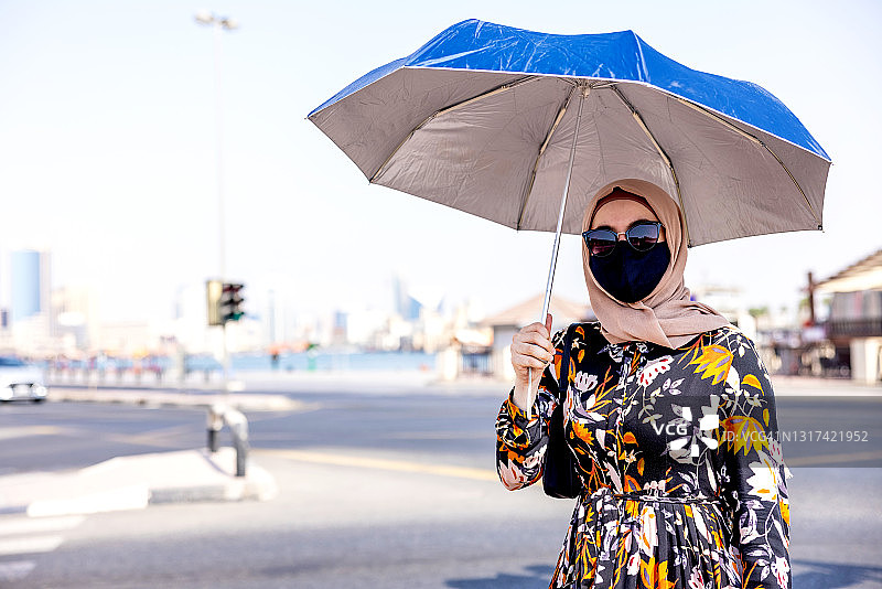 手持雨伞的中东女孩肖像图片素材
