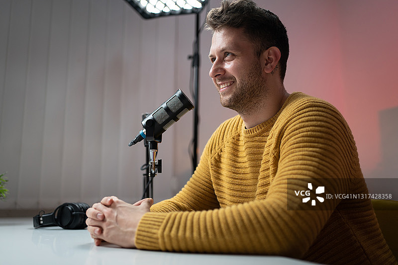 微笑的年轻男子在录音室录制节目图片素材