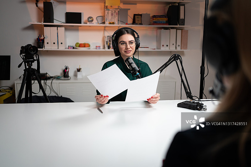 女广播主持人倾听嘉宾谈论主题图片素材