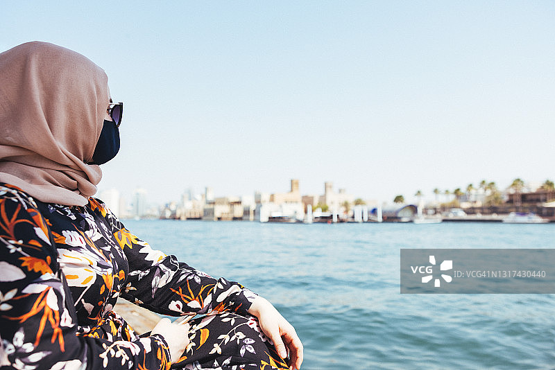 戴着口罩在迪拜乘船游览的中东女孩图片素材