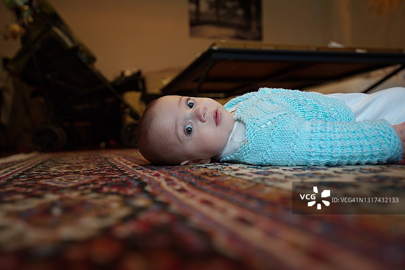 躺在地板上的可爱男婴肖像图片素材