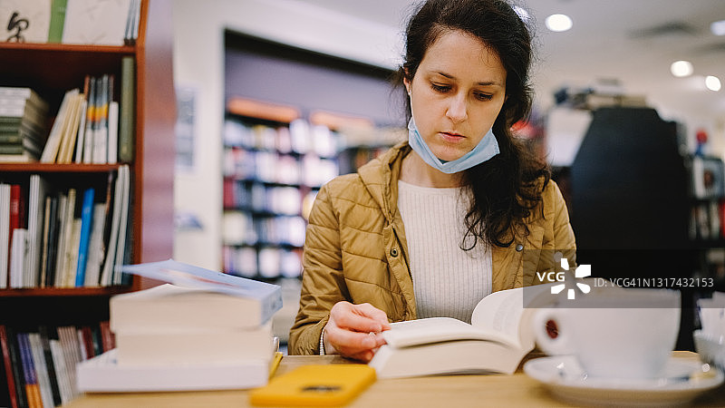疫情期间，女人在书店咖啡馆挑选新书图片素材