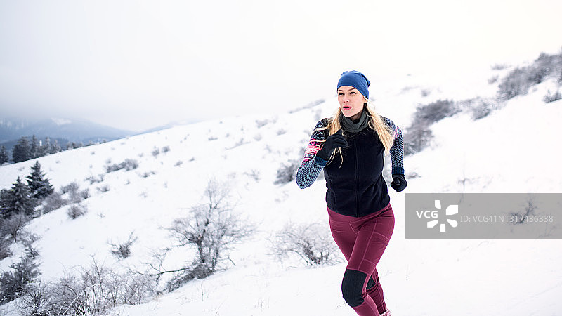 在冬季大自然中慢跑的中年妇女肖像图片素材