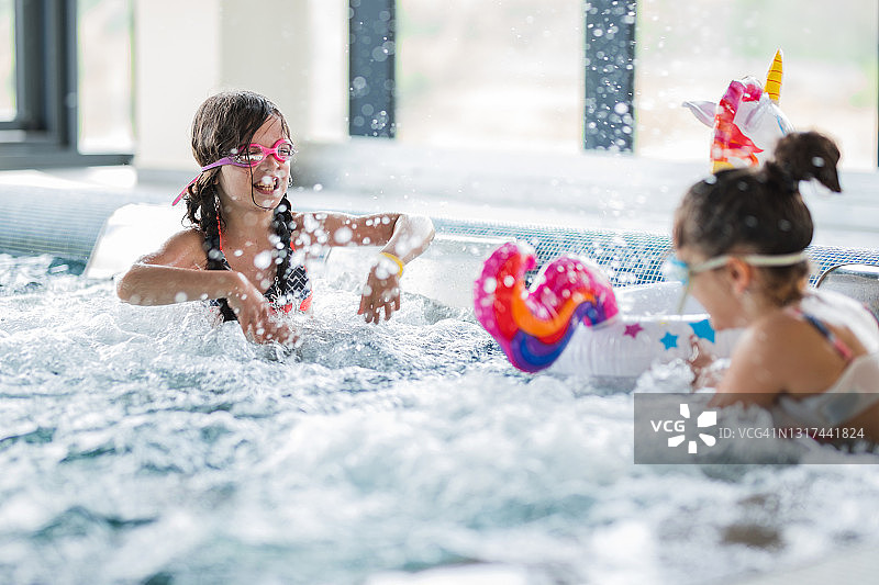 在游泳池里玩水的年轻女孩们图片素材