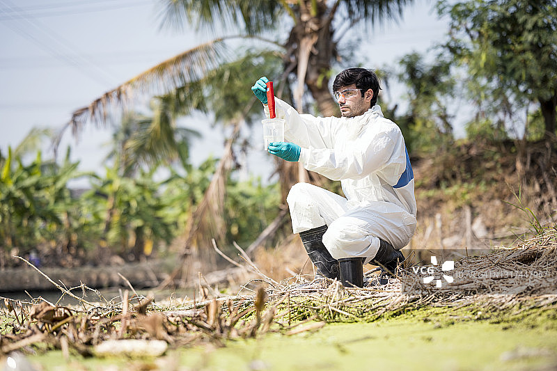 男科学家读取pH值或检查水样中的有毒水，他穿着防护工作服在户外工作图片素材
