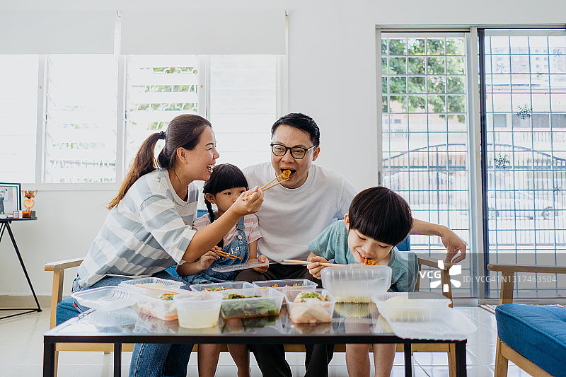亚洲家庭在客厅里享用外卖食物图片素材