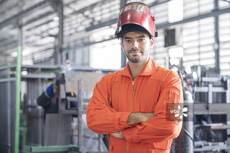 工厂里交叉双臂的年轻工业工程师图片素材