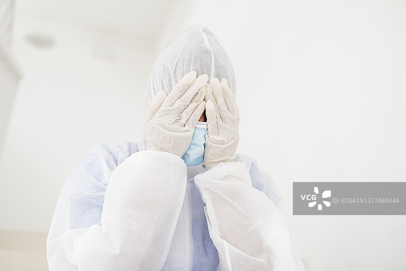 疲惫的医生用手捂着脸图片素材