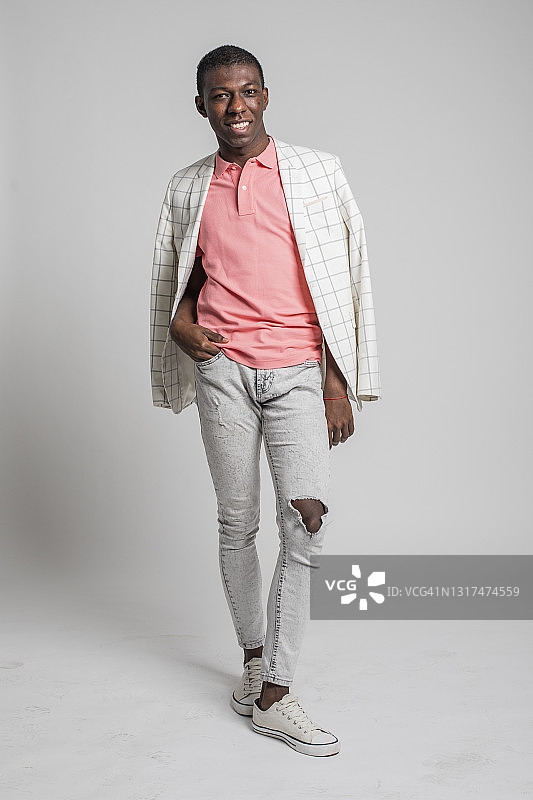 在灰色背景上欢笑、跳舞和移动的时尚年轻人图片素材