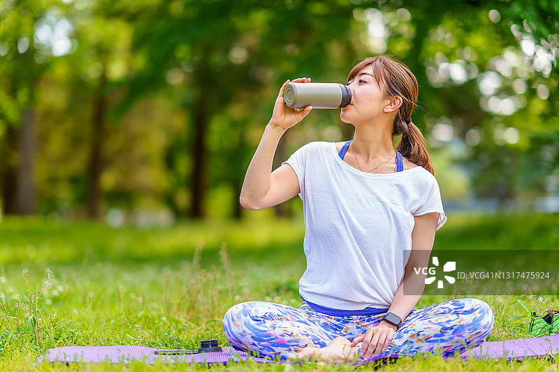 户外运动训练间隙喝水的运动女人图片素材