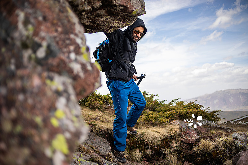 徒步旅行者爬山，用Gopro相机拍摄视频，为他的视频博客制作视频图片素材