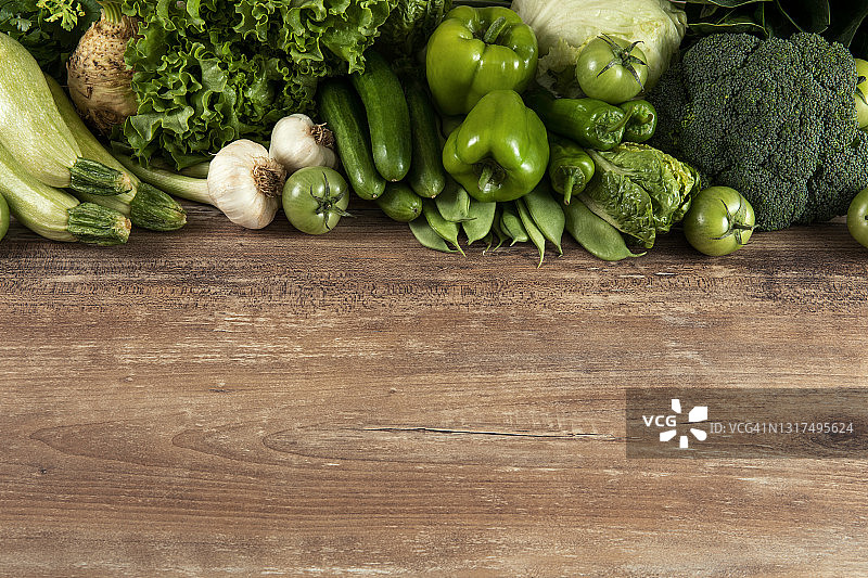 棕色木桌上的新鲜绿色蔬菜图片素材