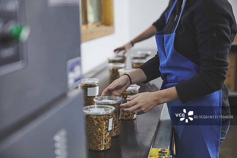工厂生产线上包装腰果盒的男工人侧视图图片素材